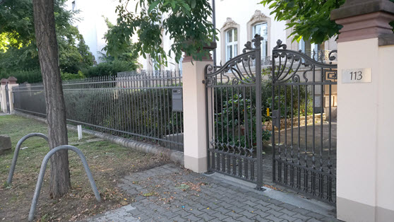 Selbst im Schatten und trotz Matt-Lackierung sind die Doppeltore und der über 20 Meter lange Zaun eine imposante Erscheinung und Einrahmung für die Opel-Villa, die das Stiftungs-Haus der action 365 ist.