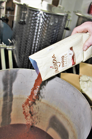 Gemahlener indígena-Kaffee wird in den Behälter geschüttet, um mit kaltem Wasser vermischt zu werden, daraus entsteht Cold Brew Kaffee.