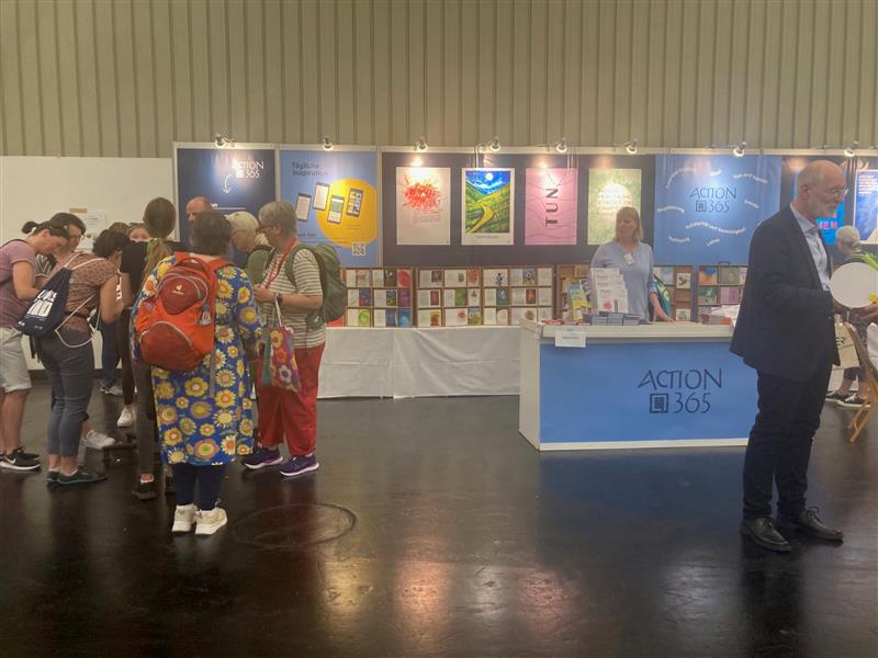 Am Tisch zur Karten-Schreib-Aktion (links im Foto der umlagerte Tisch) haben sich stets viele Menschen zu einer Traube aufgefunden, um mit der Karte „In der Hoffnung“ einem lieben Mitmenschen eine Freude zu machen.